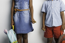 a brother and sister holding book bags 