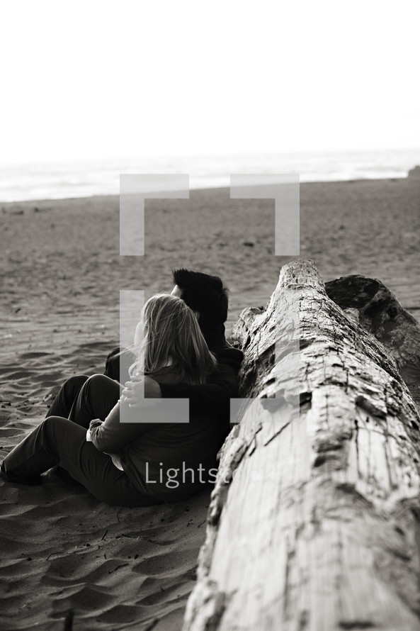 Happy couple sitting on beach sand tree marriage relationship love