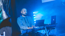 a man playing a digital piano on stage 