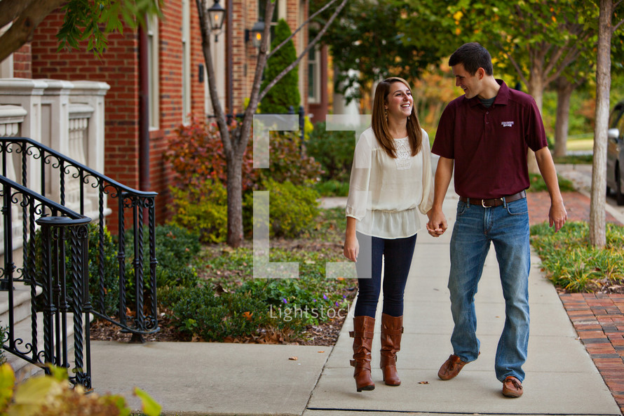 Happy couple walking on sidewalk