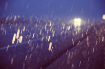 headlights from cars and falling rain 