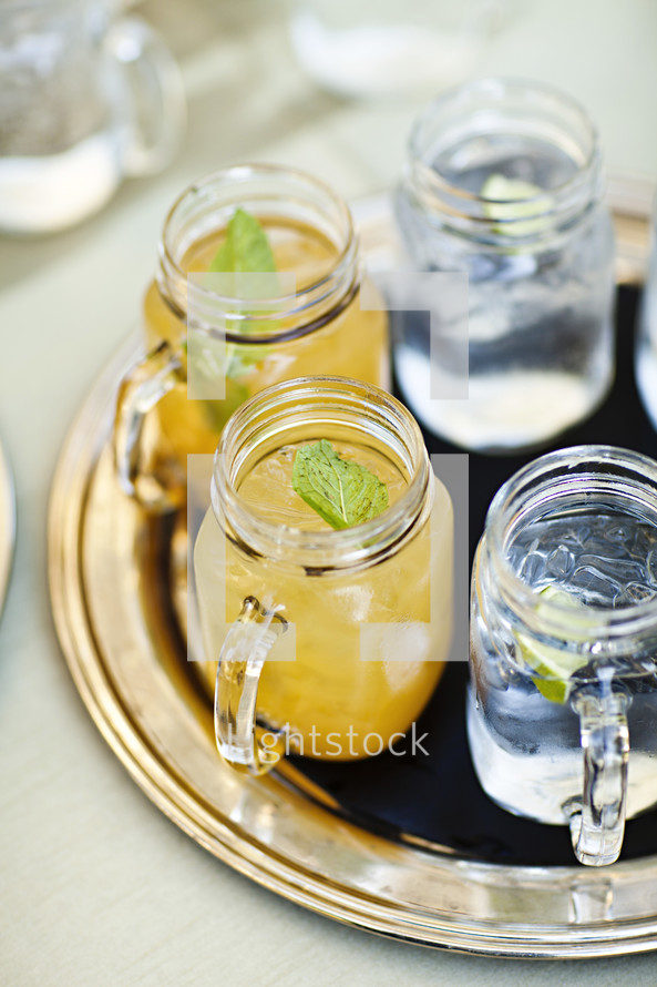 Drinks sitting on a tray lemonade and ice water mason jars