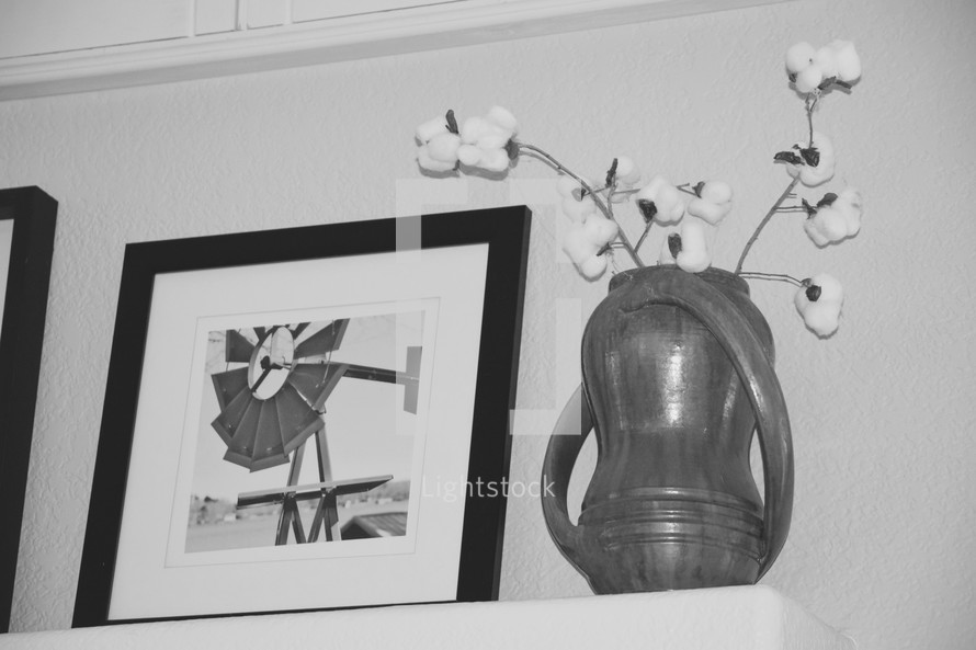 framed windmill photograph and cotton sprays in a pottery vase on a mantel 