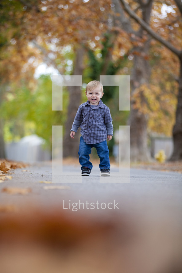 Toddler standing on sidewalk smiling