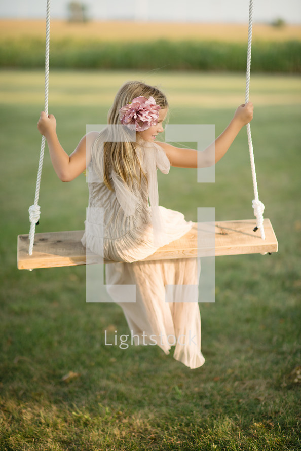 A young girl sitting on a swing