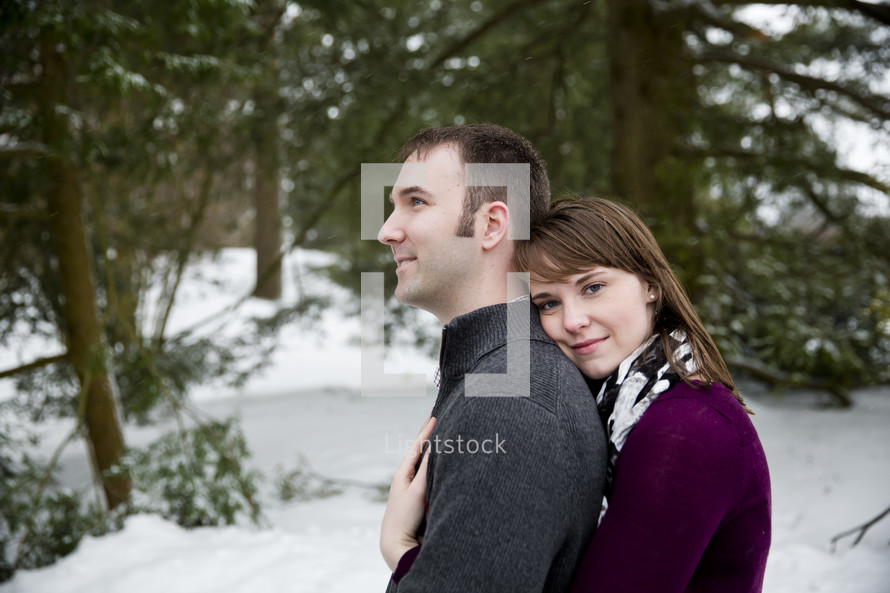 Embracing couple standing outside in the snow.