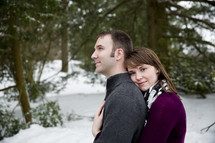 Embracing couple standing outside in the snow.