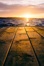 wood boards on a dock at sunset 