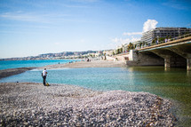 a fisherman on a rocky beach in Nice, France 