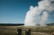 people watching a geyser 