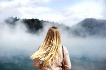 a woman standing outdoors in the fog 