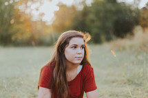 teen girl thinking in a field 