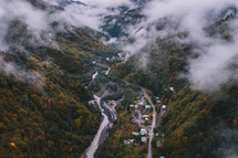 Foggy mountains and village in the river valley