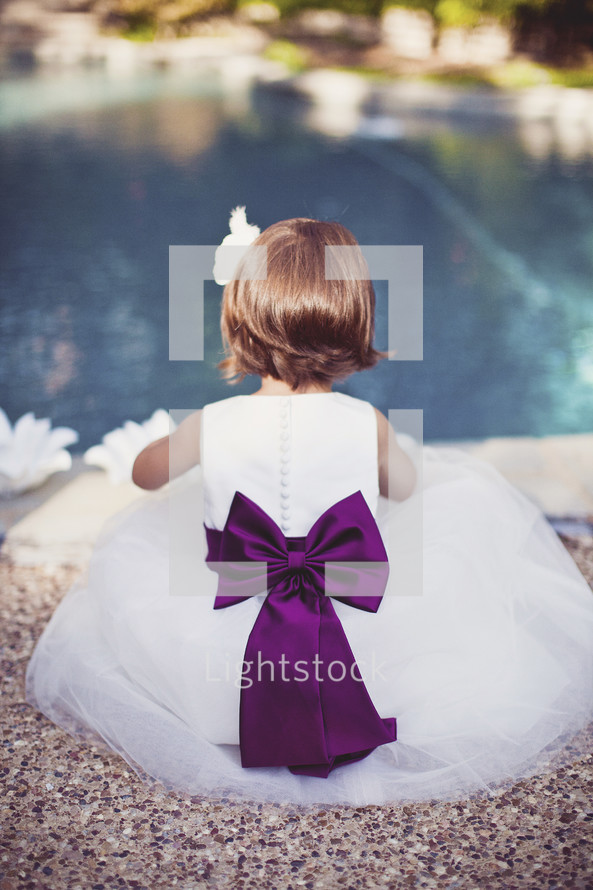 flower girl sitting by a pool