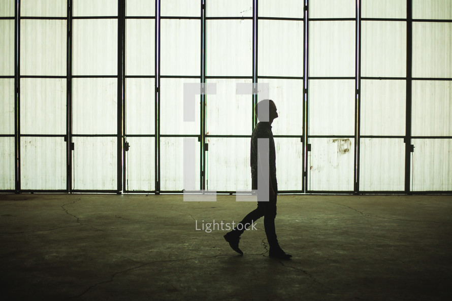 a man walking in an empty warehouse 