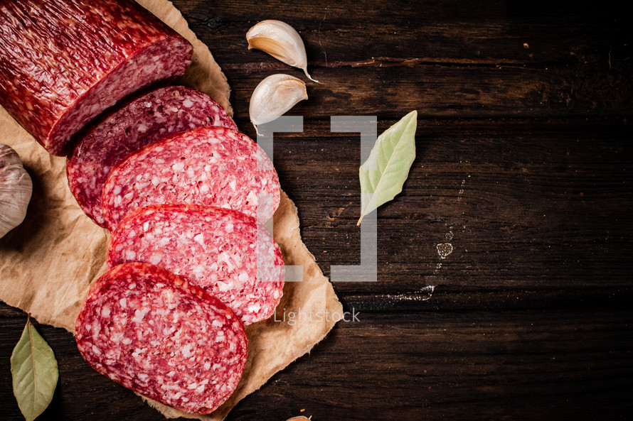 Delicious salami sausage on the table. On a black background. High quality photo