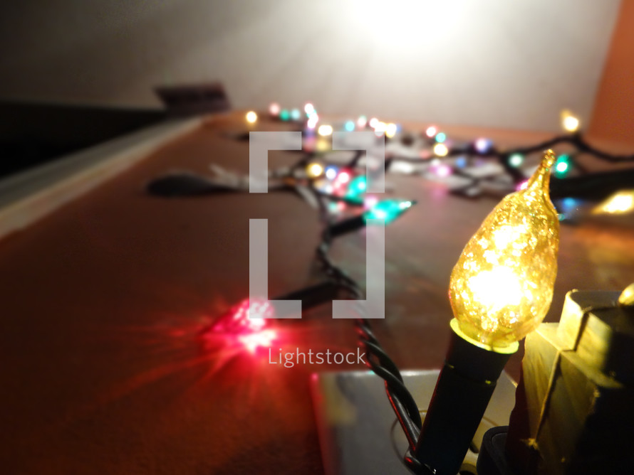 Low angle view of large Christmas lights displayed on wall with focus on yellow bulb near bottom of wall