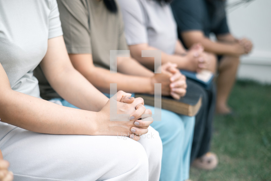 Group praying with folded hands