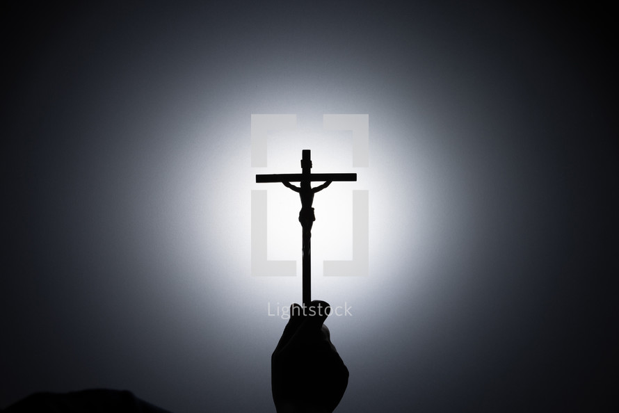 Silhouette photo - hand holding a cross