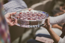 passing a tray of communion cups during a worship service