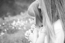 Mother and daughter in prayer outdoors.