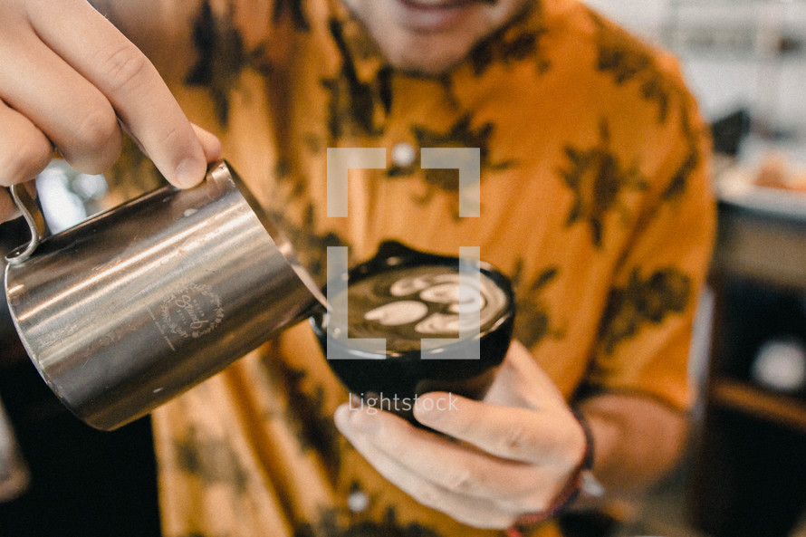 barista pouring creamer in a mug 