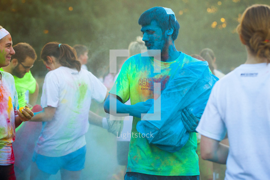 teens tossing color packets at a color run