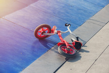 kid's bicycle lying on a skateboard ramp park