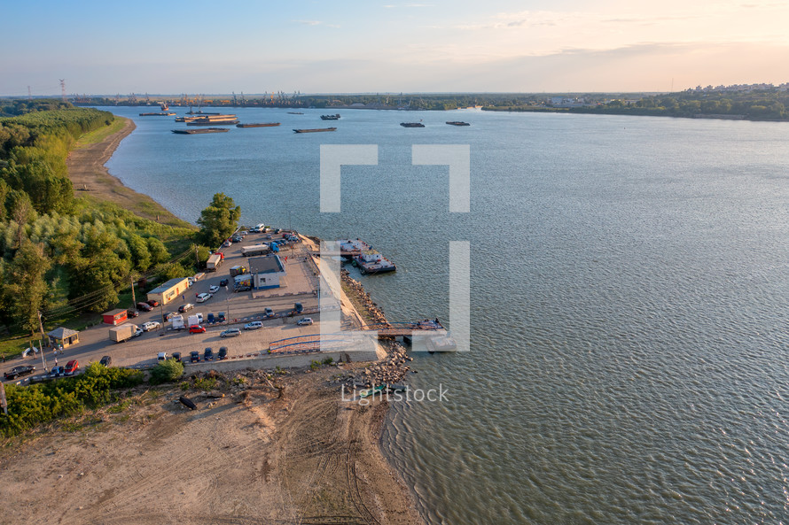 Aerial view of Danube ferry near Galati City, Romania. Danube River near city with sunset warm light