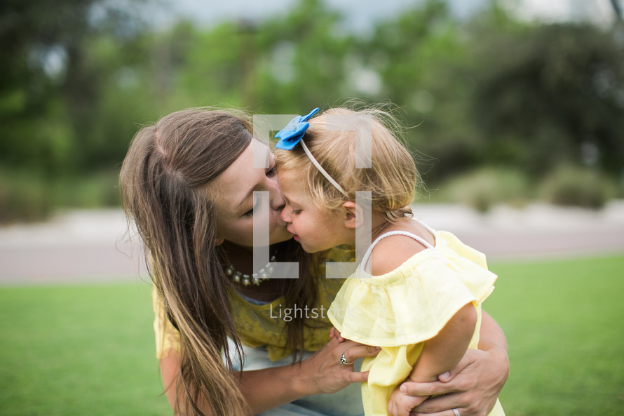 mother kissing her daughter 