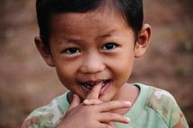 a young child with his finger in his mouth 
