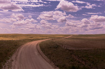 a curvy dirt road in a rural landscape 