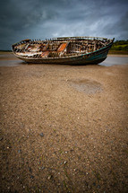 old beached boat on sand 