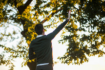 a man with raised hand standing outdoors 