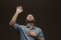 A man standing with raised hand in worship to God 