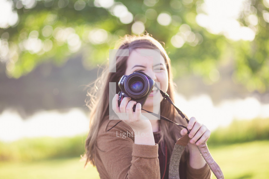 a young woman holding a camera 