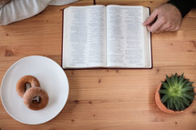 donuts on a plate and a woman reading a Bible 