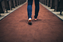 feet of a woman walking down the entrance of a church 