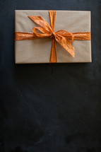 a wrapped gift with orange bow 