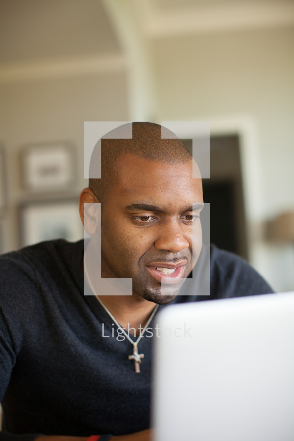 African-American man looking at a compeer screen 