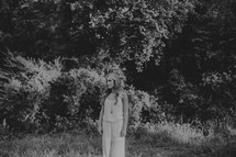 young woman standing in a field alone 