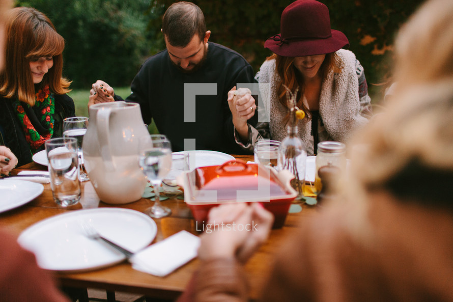 Friends Praying Together Before Thanksgiving Dinner 