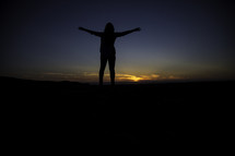 silhouette of a woman with outstretched arms 