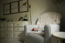 a newborn baby in a nursery chair 