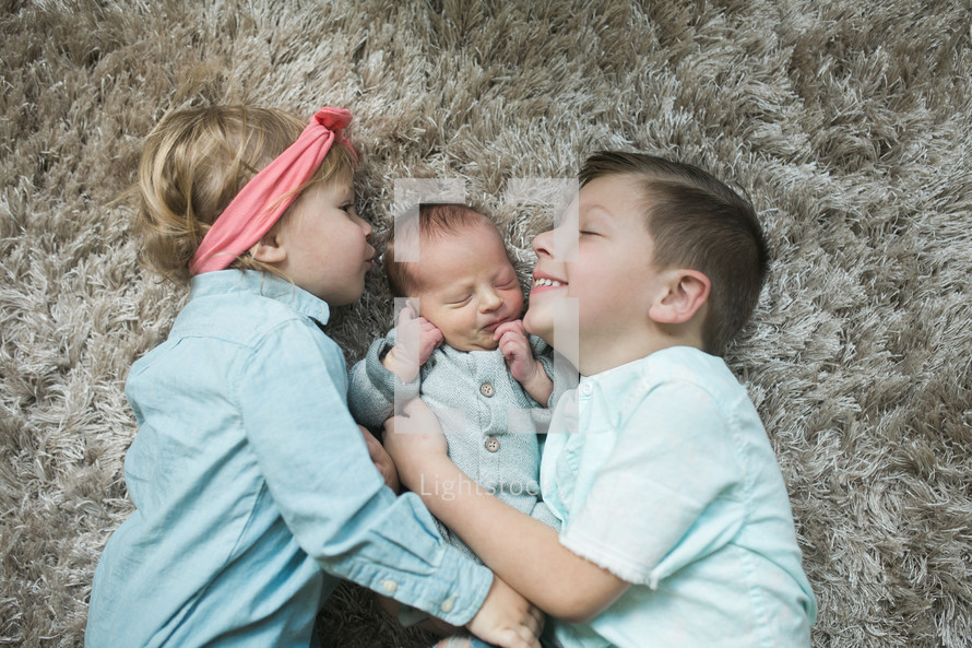 big brother and big sister with their newborn baby brother 