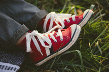a child's red sneakers in the grass