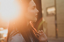 side profile of a woman standing in sunlight 