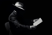 Faceless Man Wearing Hat and Reading The Holy Bible
