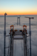Aerial footage of bridge peeking out from clouds at sunset