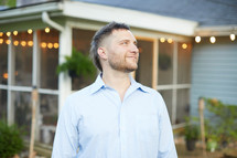 a man standing outdoors in a back yard 